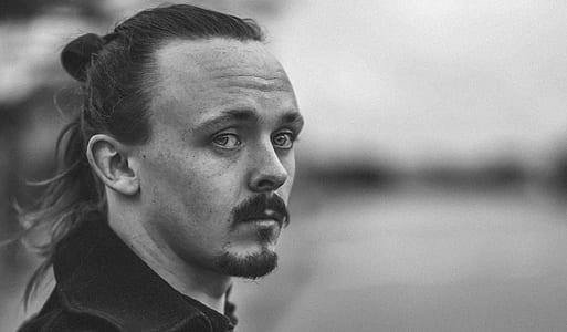 grayscale photo of man wearing black shirt thumbnail