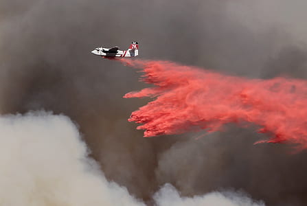 white and red airplane dropping red ash on the sky thumbnail