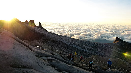 group of people hiking up mountain peak during daytime thumbnail