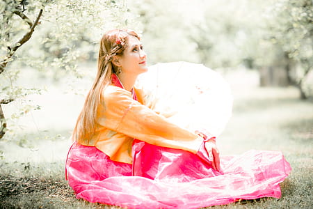 woman in yellow and pink dress sitting on grasses thumbnail