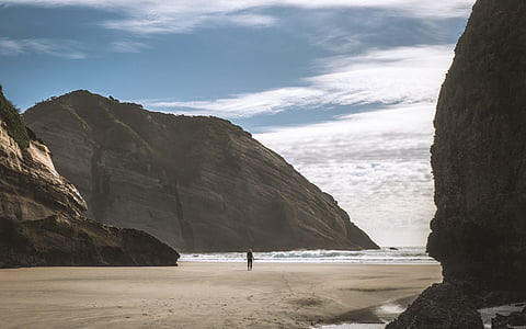 person standing on sea shore during daytime thumbnail