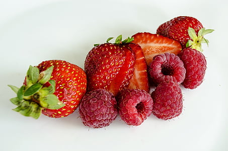 sliced strawberries and raspberries isolated on white background thumbnail