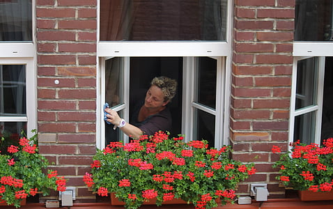 woman cleaning clear glass window thumbnail