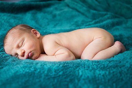 baby sleeping on teal comforter thumbnail