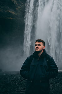 man standing in front of waterfalls thumbnail