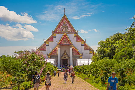 people walking on pathway through temple under nimbus clouds and blue calm sky thumbnail