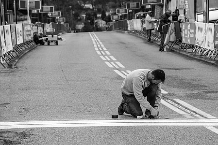 man kneeling on street grayscale photography thumbnail