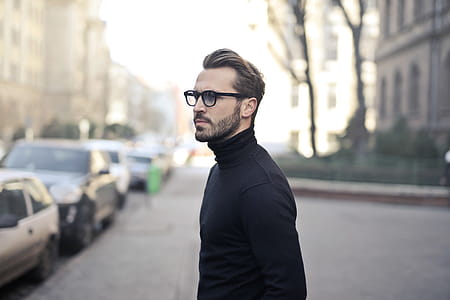 Young bearded male wearing black turtleneck top and eyeglasses posing at the street thumbnail