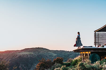 woman standing near patio of house near cliff thumbnail