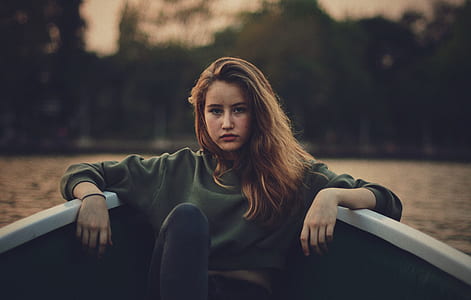 sitting woman on gray boat's edge selective focus photo thumbnail