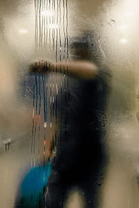 person standing behind glittered glass thumbnail