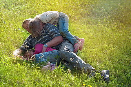 man carrying girl on green grass field thumbnail