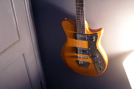 brown electric guitar hanged on wall thumbnail