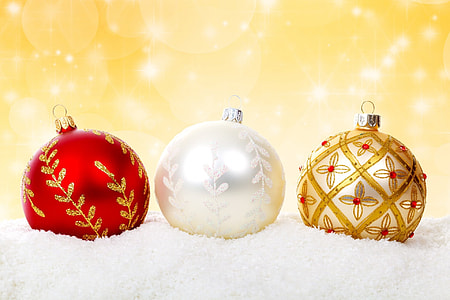 three assorted-color baubles on white textile thumbnail