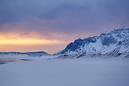 open field near body of water background of snow coated mountain thumbnail