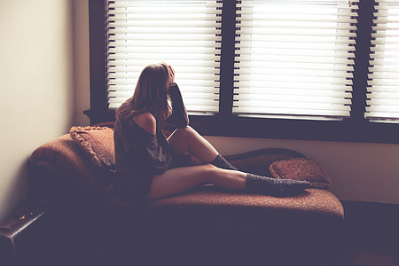 A woman sitting down by a window thumbnail