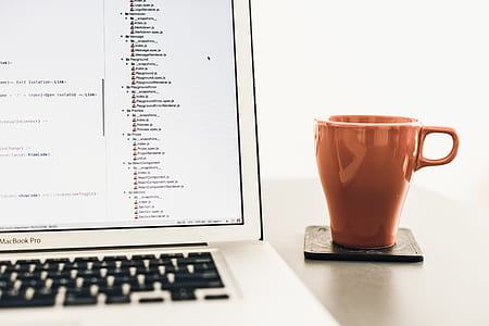 MacBook Pro near brown mug on table thumbnail