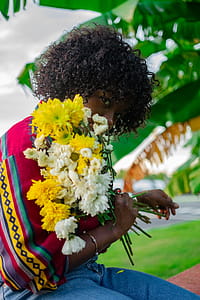 Girl Holding White and Yellow Petaled Flowers thumbnail