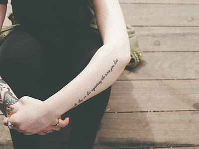 woman with tattoos wearing black pants thumbnail