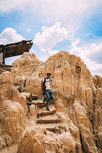 man walking on stone mountain stairs thumbnail