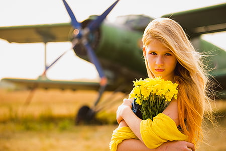 woman wearing yellow top holding white flowers thumbnail