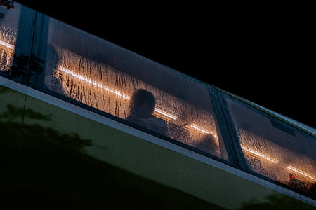 group of people sitting inside bus while raining during night time thumbnail