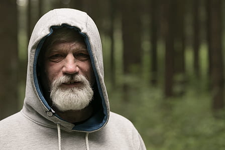 selective focus shot of man in gray hoodie near trees thumbnail