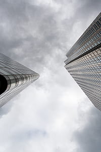 two tall buildings below gray clouds thumbnail