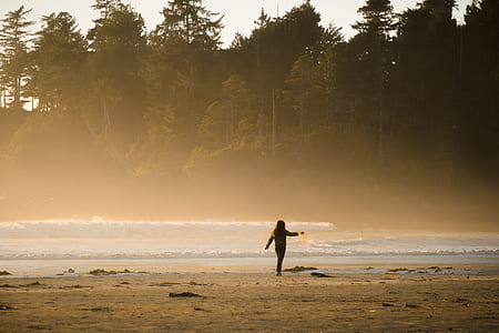 woman walking on field with beach waves thumbnail
