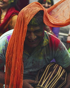 Man Wearing Green Polo Shirt Covered in Colored Powder Smiling thumbnail