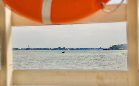 boat on sea taken under white clouds during daytime thumbnail