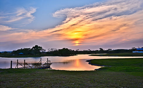 body of water in middle of grass field thumbnail