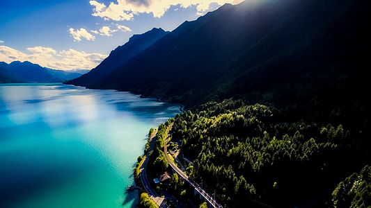 aerial photo of body of water near mountains at daytime thumbnail