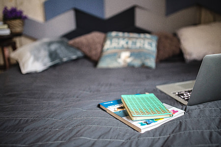 Laptop with books on a bed thumbnail