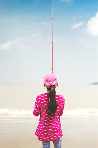 Woman in Pink Long-sleeved Shirt Holding Red Fishing Rod thumbnail