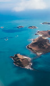 brown islands in between sea during daytime thumbnail