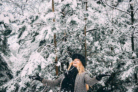 woman standing near snow covered trees thumbnail