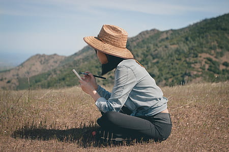 woman holding makeup brush sitting on grass field thumbnail