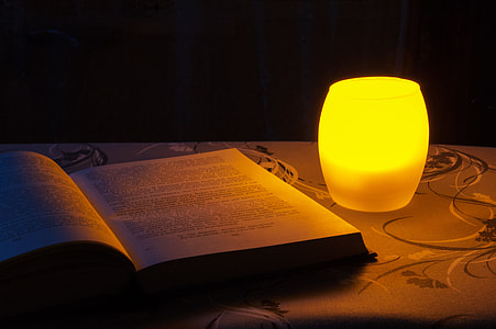 softbound book near yellow desk lamp inside room thumbnail
