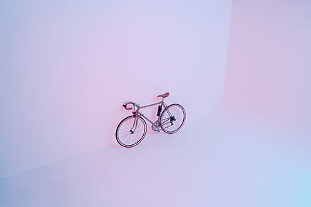 red and black road bike leaning on white wall thumbnail
