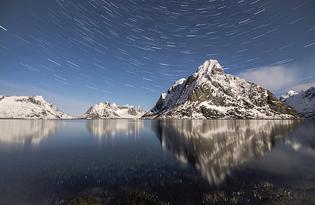 snow covered rock formation on body of water thumbnail