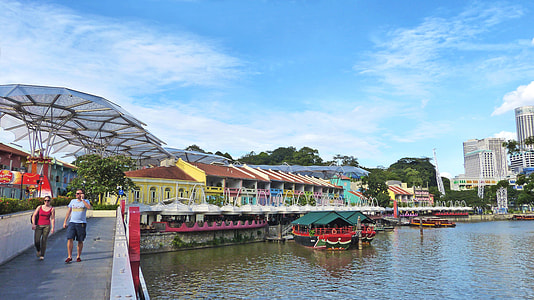 two persons walking near body of water during daytime thumbnail