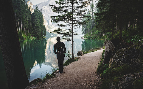 person standing in front of lake during daytime thumbnail