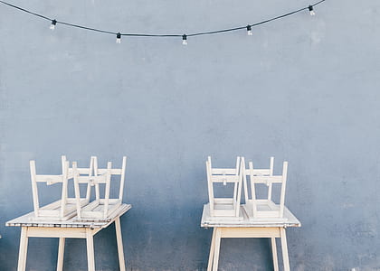 four white wooden stools on white wooden tables thumbnail
