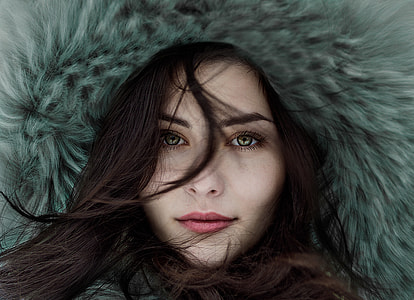 woman with black hair and green eyes wearing blue fur coat thumbnail