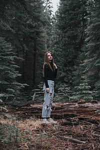 woman standing in the middle of forest thumbnail
