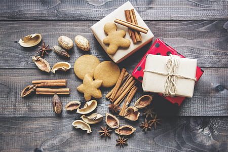 assorted nut shells and baked cookies with two white and red gift boxes on gray wooden surface thumbnail