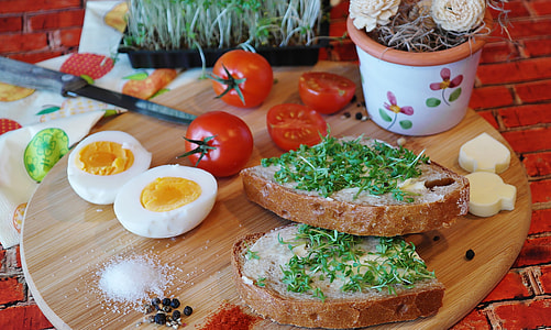 cooked eggs, tomatoes, and breads served on brown wooden tray thumbnail