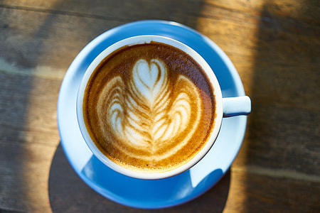 white ceramic mug with flavored coffee on top of white ceramic saucer thumbnail