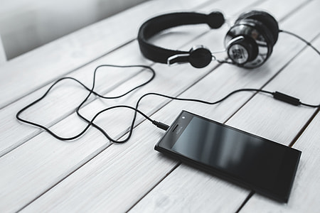 Black smartphone and headphones with various items thumbnail